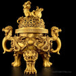 Gold-colored traditional Chinese incense burner with intricate designs on a black background