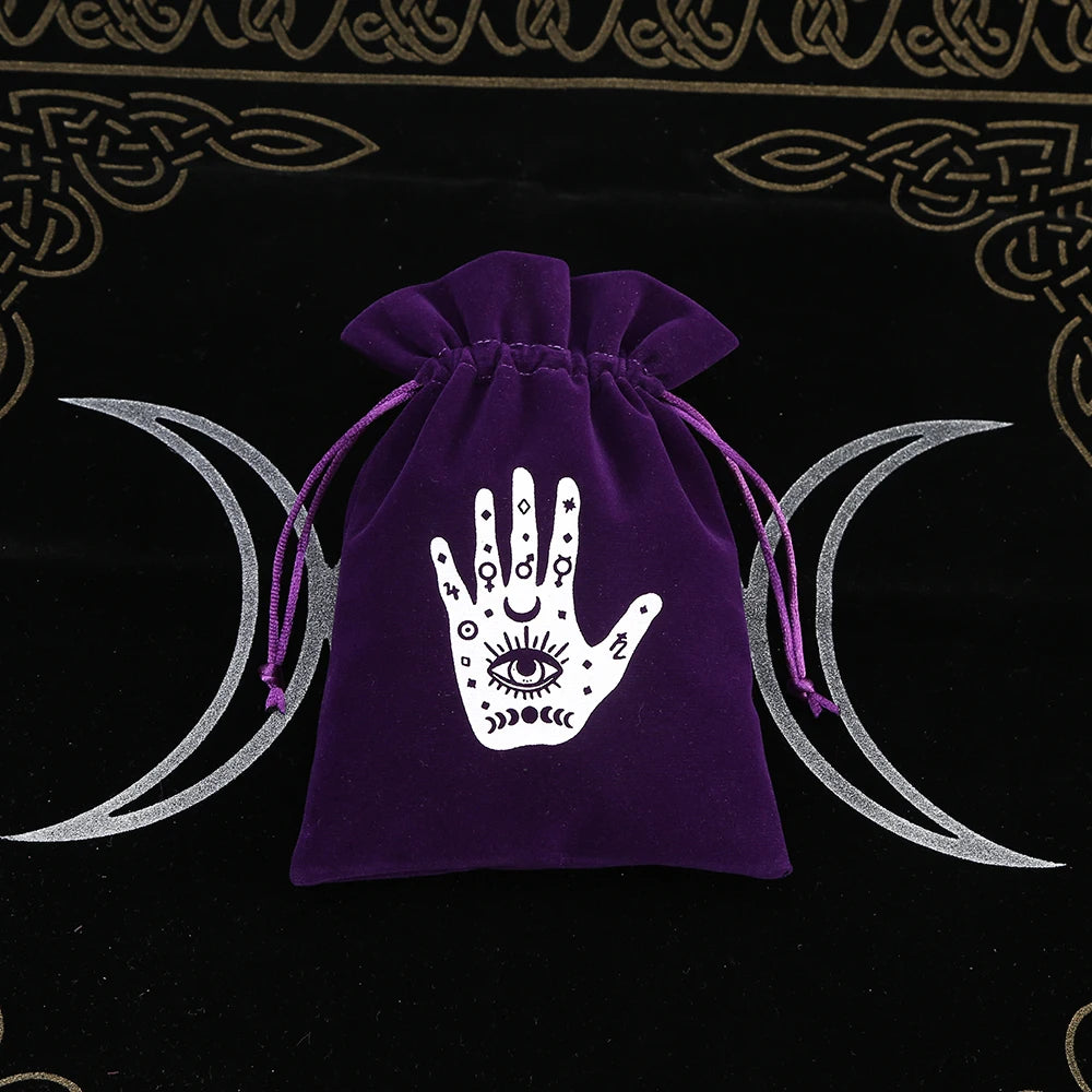 Purple drawstring bag with a white hand design featuring an eye on a black background with moon symbols.