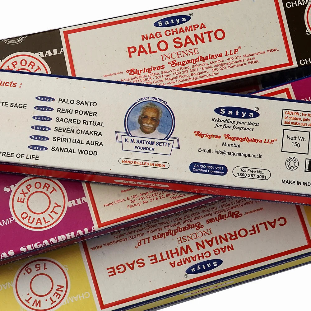 Stack of Satya Nag Champa incense packaging with product details.