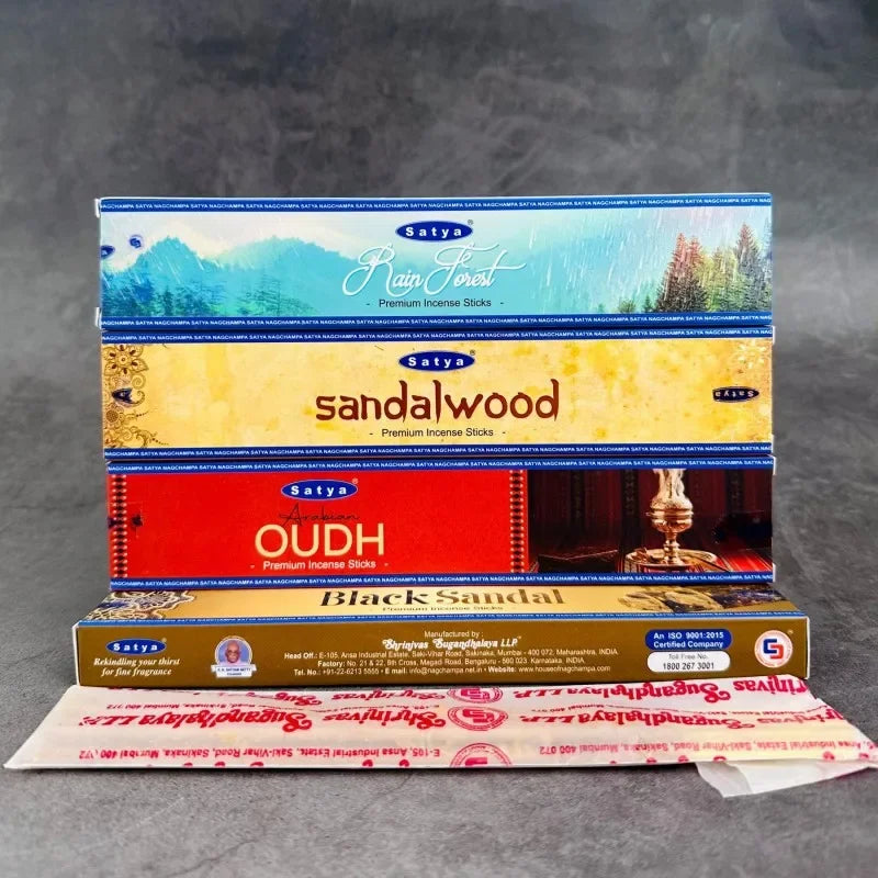 Stack of Satya incense stick boxes on a gray background