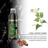 Bottle of herbal hair dye with green leaves and dried herbs on a dark background