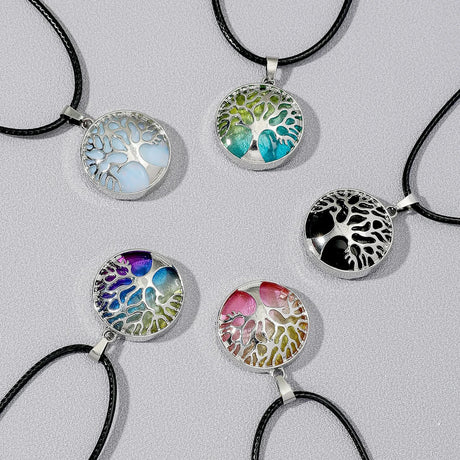 Tree of Life necklaces with colorful designs on a gray background