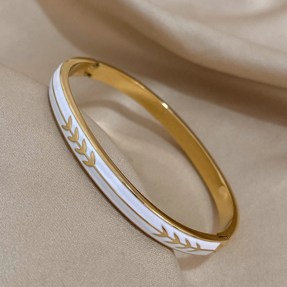 Gold and white bracelet on a beige fabric background