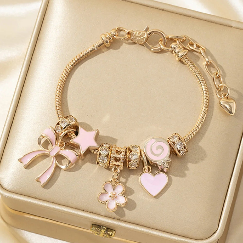 Gold bracelet with various charms on a gold jewelry box