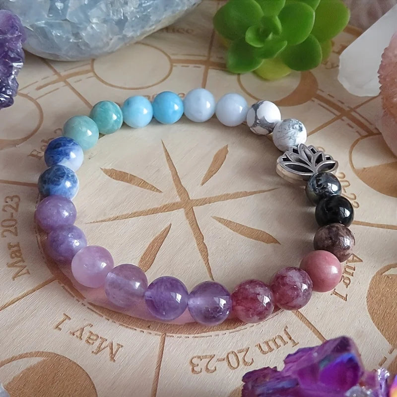 Multicolored beaded bracelet on a wooden surface with engraved dates