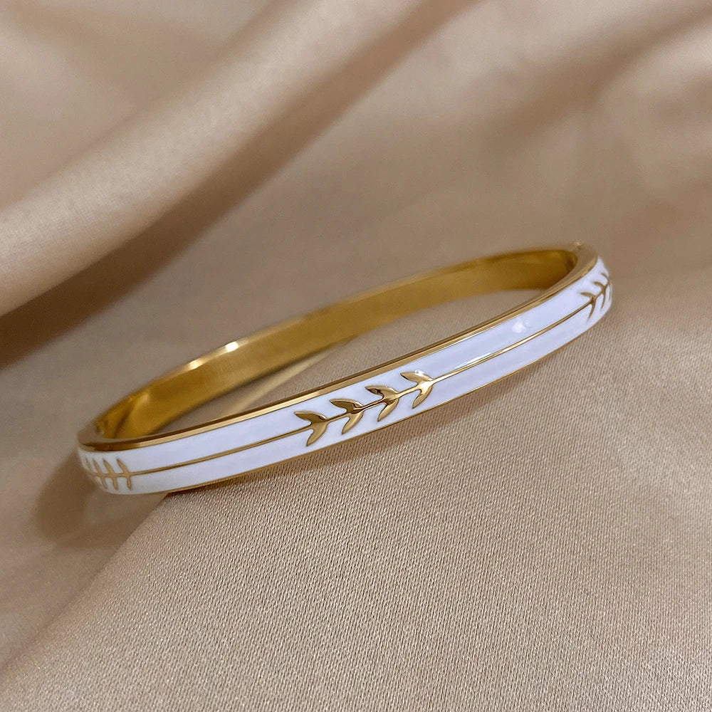 Gold and white bracelet on a beige fabric background