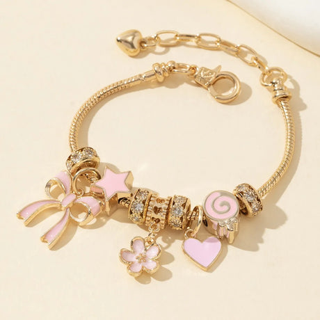 Gold bracelet with pink and gold charms on a beige background