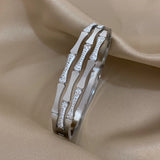 Silver bracelet with diamond accents on a beige fabric background