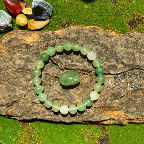 Green jade bracelet on a rock with colorful stones in the background