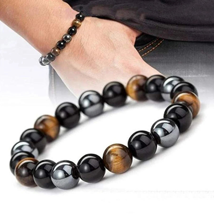 Beaded bracelet with black, brown, and gray beads on a plain background