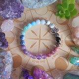 Colorful beaded bracelet on a wooden surface with crystals and plants