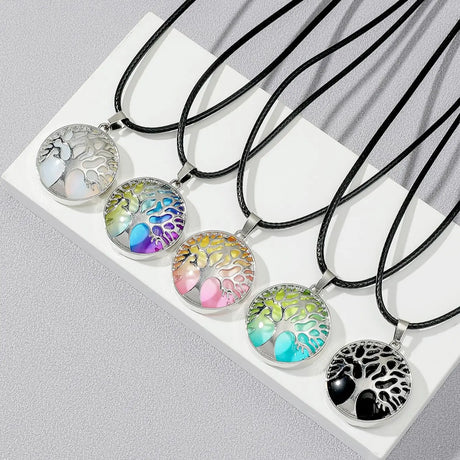 Set of tree of life necklaces with colorful designs on a white surface