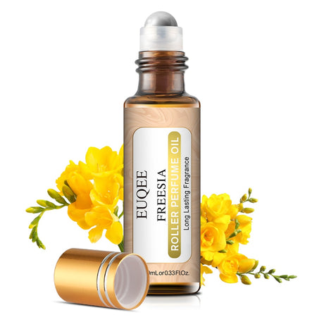 Roller bottle of Freesia perfume oil with yellow flowers on a white background