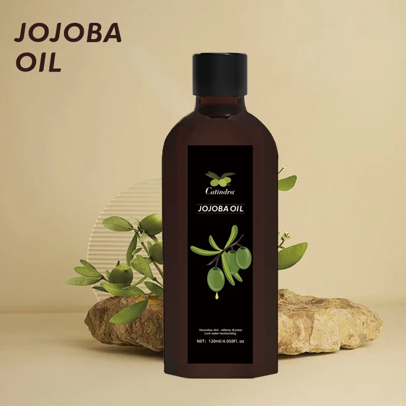 Bottle of jojoba oil with a black label featuring green leaves on a beige background