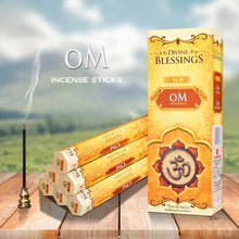 Box of Divine Blessings incense sticks with incense sticks and a holder on a wooden surface with a scenic background.