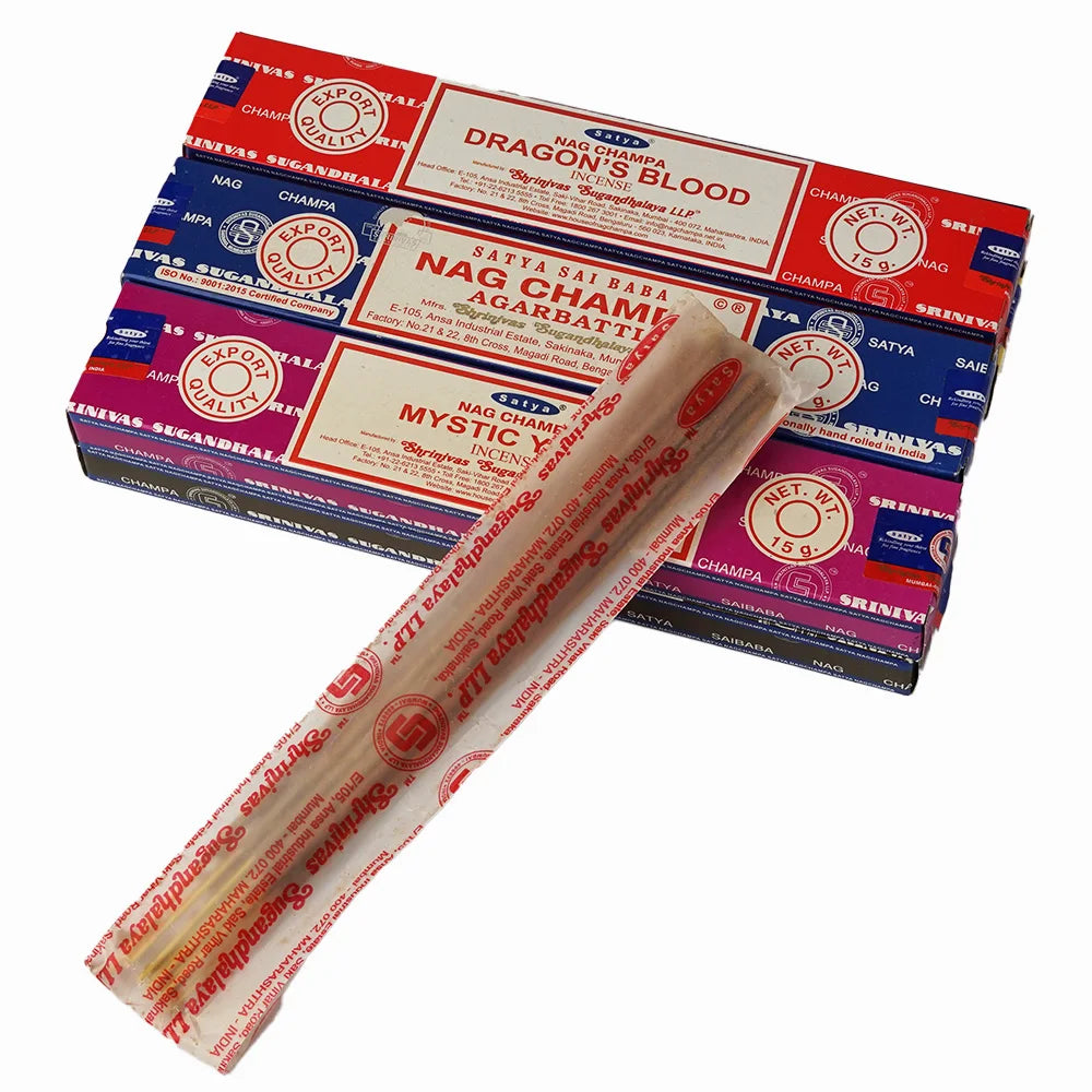 Box of Nag Champa incense sticks with a single stick in front on a white background