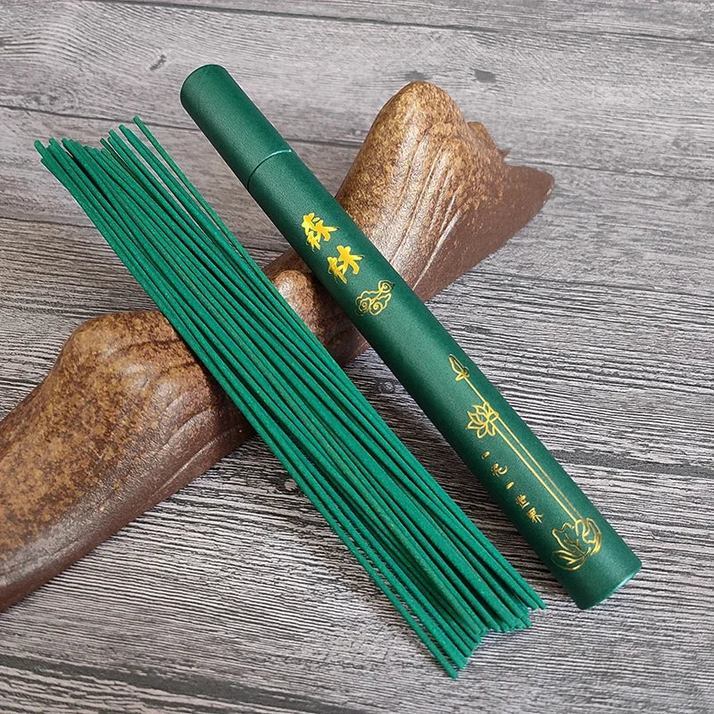 Green incense stick with packaging on a wooden surface