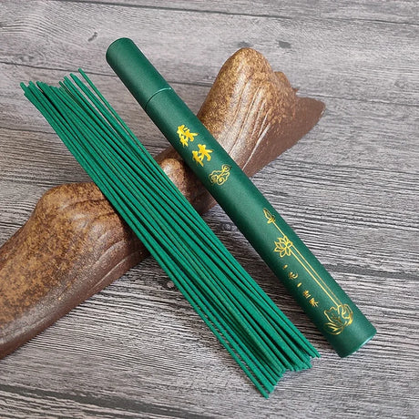 Green incense stick with packaging on a wooden surface