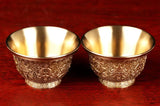 Two gold bowls on a red background with text above them.