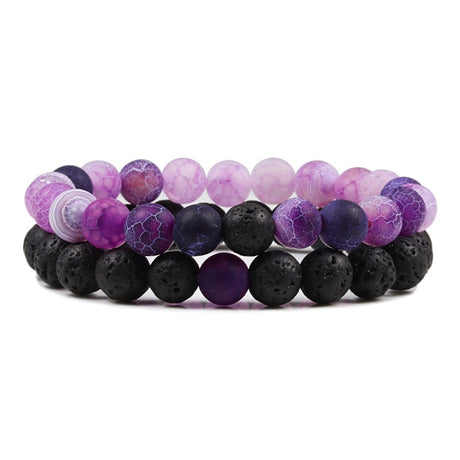 Set of three bracelets with purple and black beads on a white background