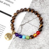Beaded bracelet with a tree of life charm on a textured surface