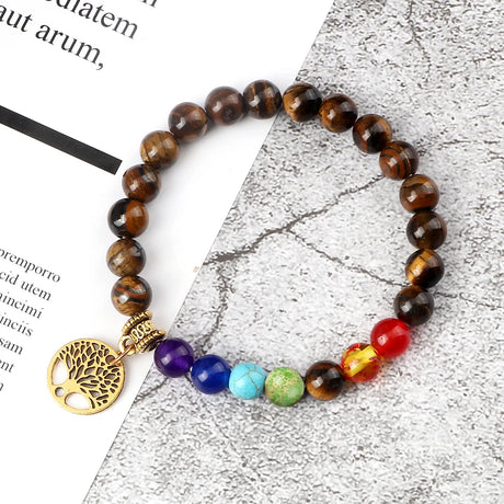 Beaded bracelet with a tree of life charm on a textured surface