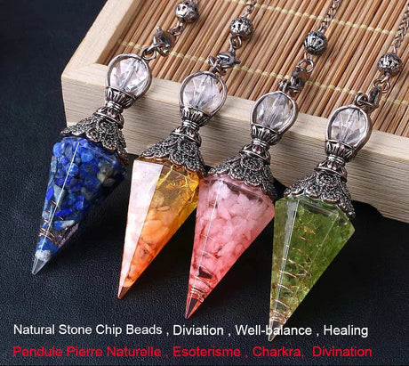 Four crystal pendulums with colored stones on a wooden surface, branded 'Cristal Jewelry'.