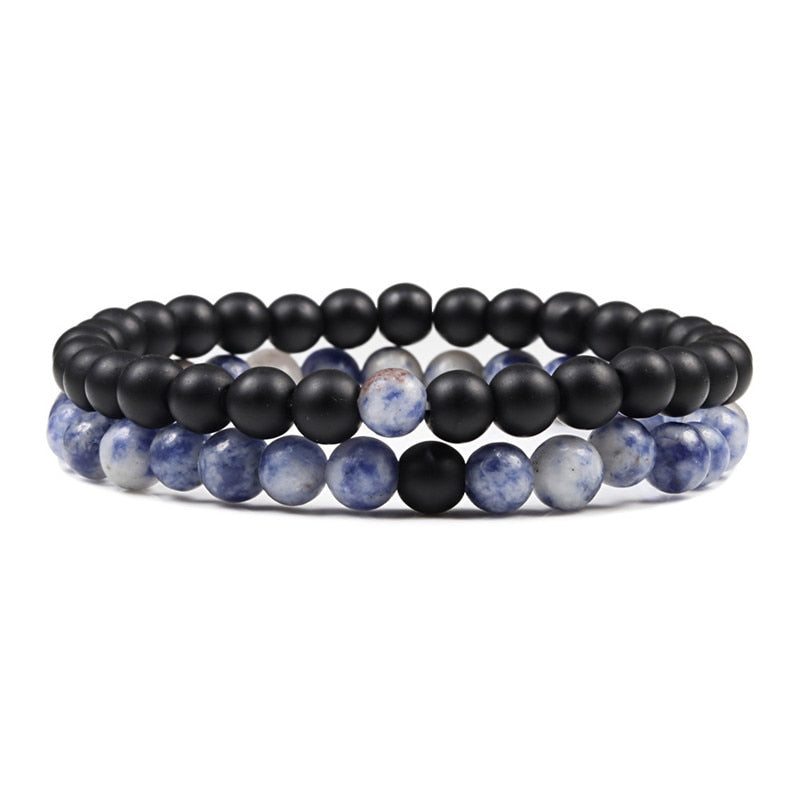 Set of three beaded bracelets with black, blue, and white beads on a white background