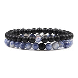 Set of three beaded bracelets with black, blue, and white beads on a white background