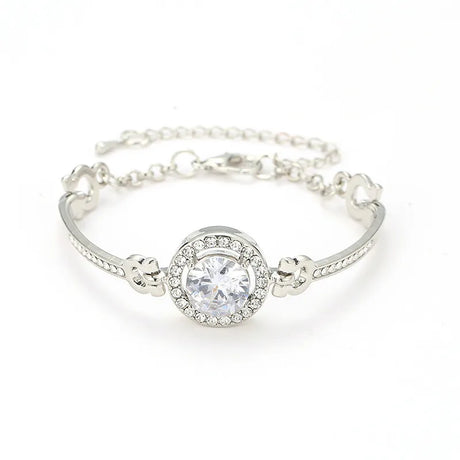 Silver bracelet with a large central gemstone on a white background