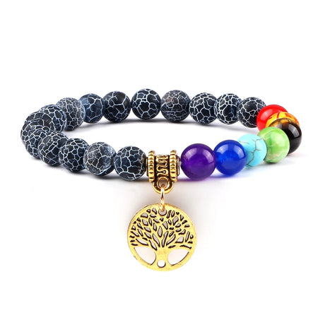 Multicolored beaded bracelet with a gold tree of life charm on a white background