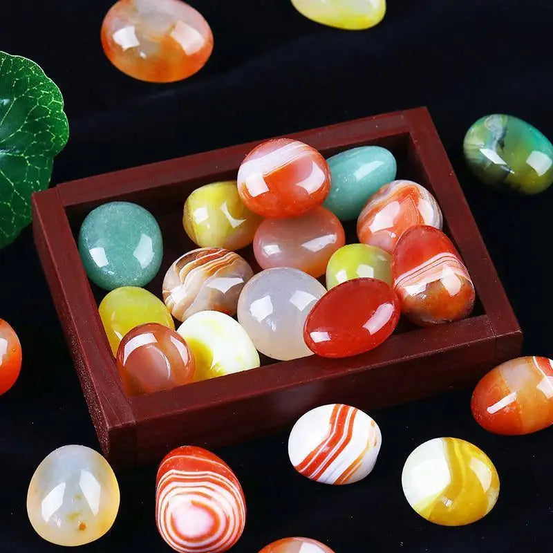 Colorful marbled stones in a wooden box on a dark background