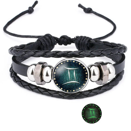 Black braided leather bracelet with silver accents and a Gemini symbol charm on a white background.