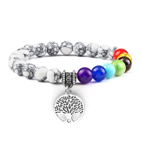 Multicolored beaded bracelet with a silver tree of life charm on a white background