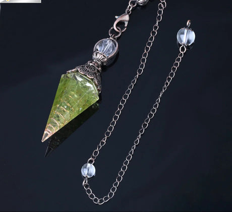 Jewelry with green crystal pendant and chain on a dark background