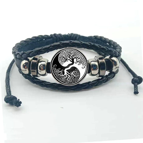 Black braided leather bracelet with silver tree of life charm on a white background