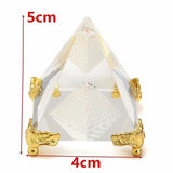 Crystal pyramid with gold bases and measurements on a white background
