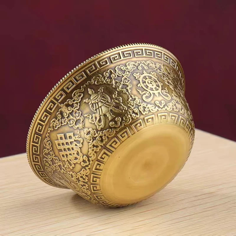 Decorative gold cup with intricate patterns on a wooden surface and red background