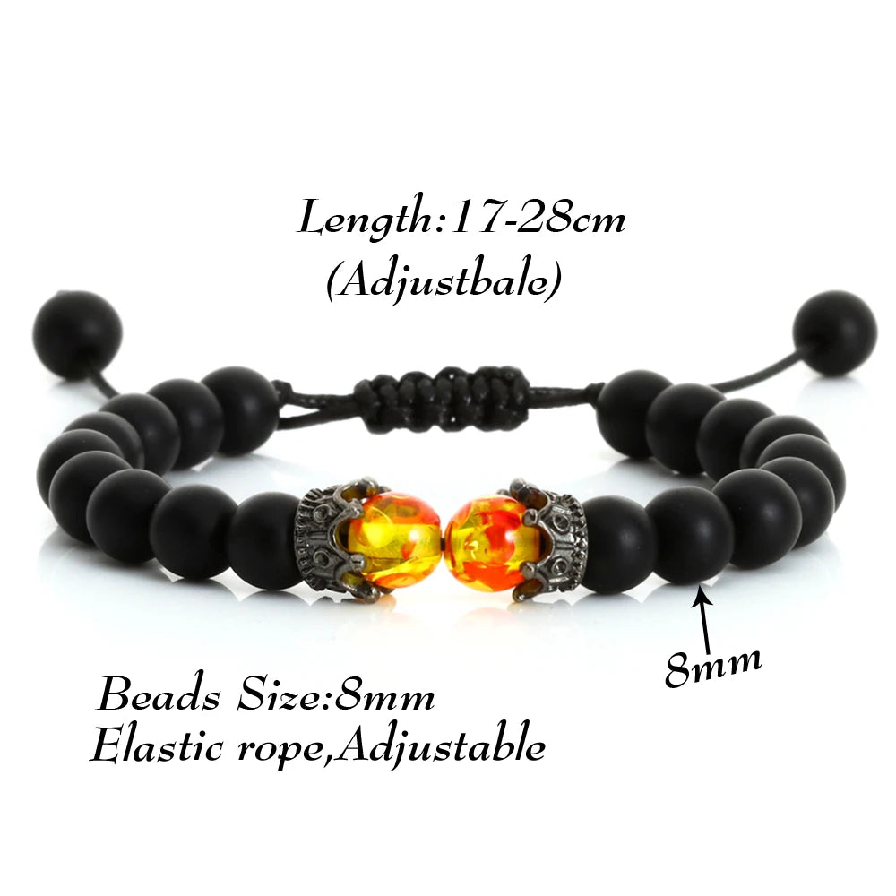 Black beaded bracelet with orange and silver beads on a white background