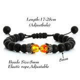 Black beaded bracelet with orange and silver beads on a white background