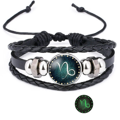 Black braided leather bracelet with silver accents and a zodiac symbol charm on a white background.