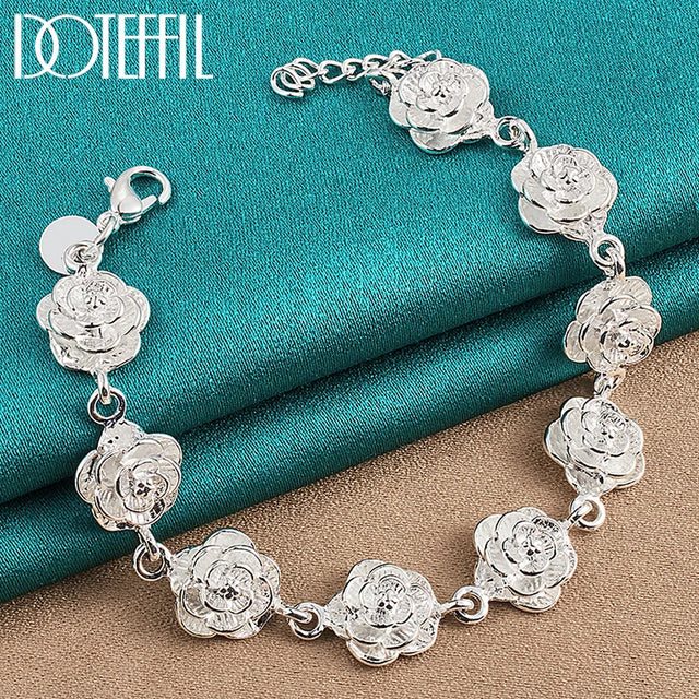 Silver floral bracelet on a textured blue and brown surface with 'Doteefil' branding.
