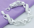 Silver bracelet with dragon design on a purple fabric background