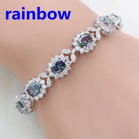 Silver bracelet with gemstones on a wrist, labeled 'rainbow'.