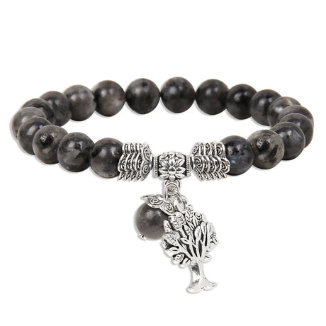 Black beaded bracelet with silver tree charm on a white background