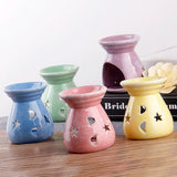 Set of colorful ceramic oil burners on a wooden surface with a white background