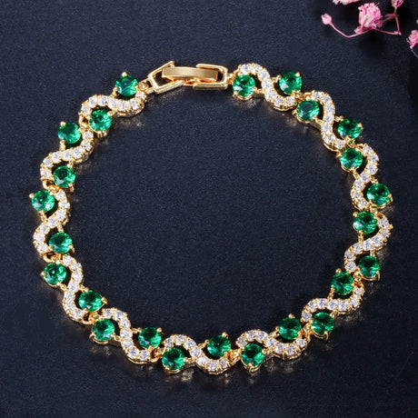 Gold bracelet with green gemstones on a dark background