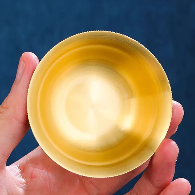 Hand holding a yellow bowl against a blue background