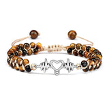 Beaded bracelet with a heart and heartbeat symbol charm on a white background