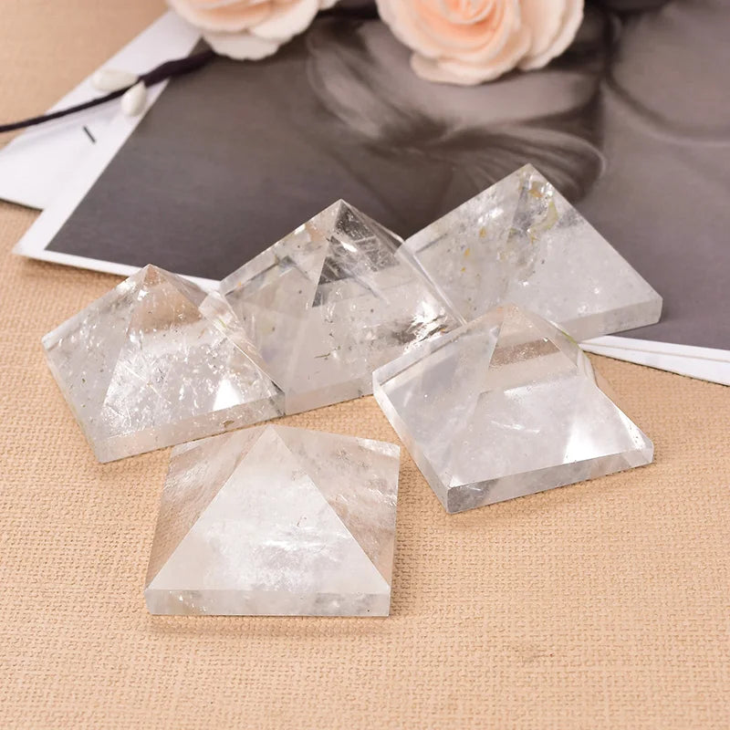 Crystal pyramids on a textured surface with flowers in the background